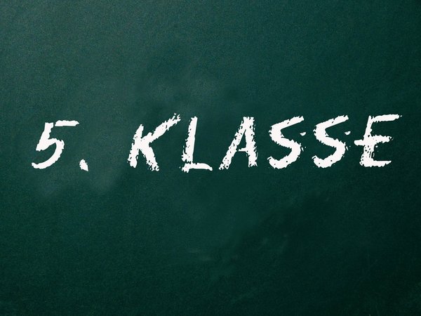 Schultafel in Grün, auf der mit weißer Kreide "5. Klasse" geschrieben steht