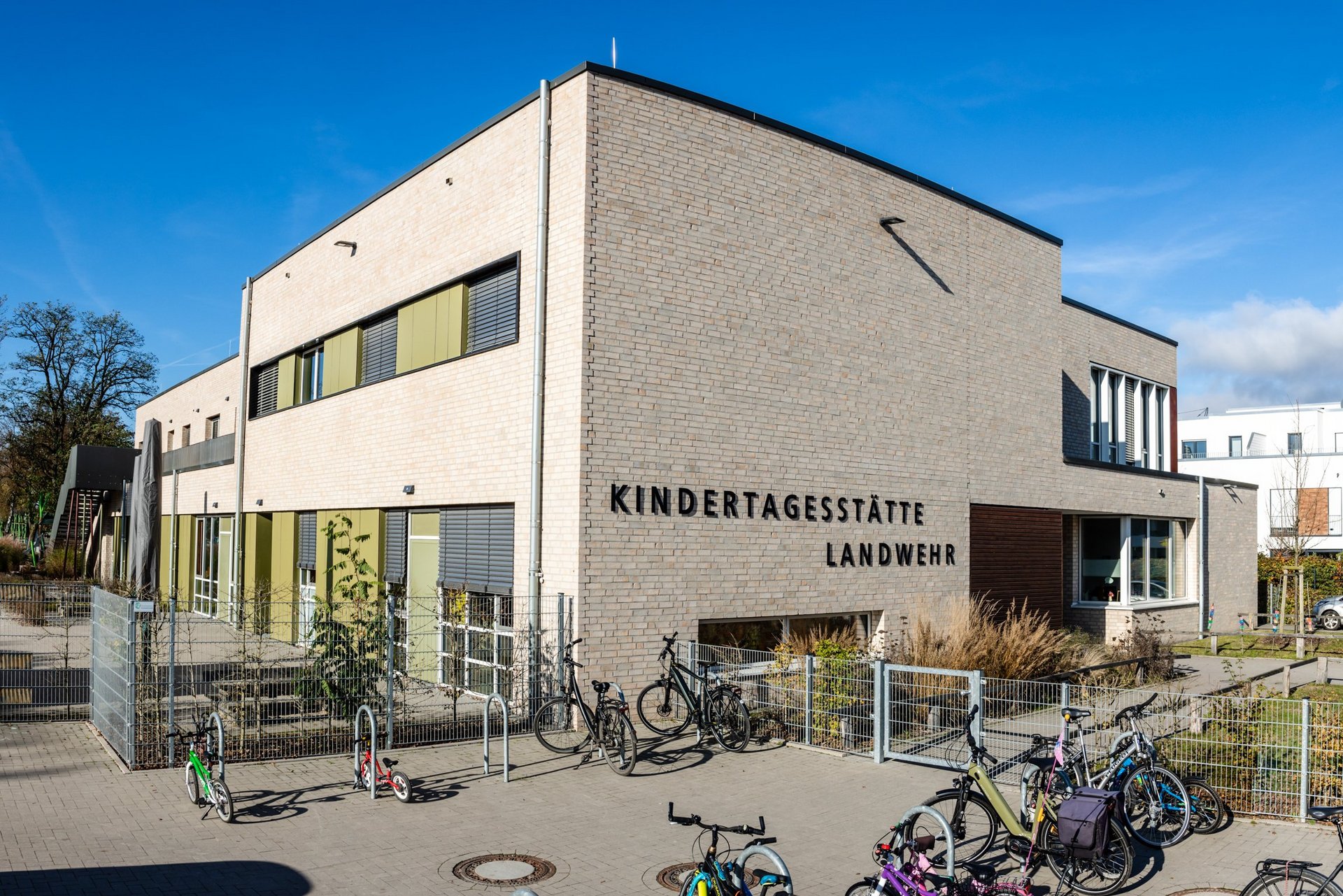 Ein großes modernes Gebäude, im Vordergrund eine Fläche mit Fahrrädern.