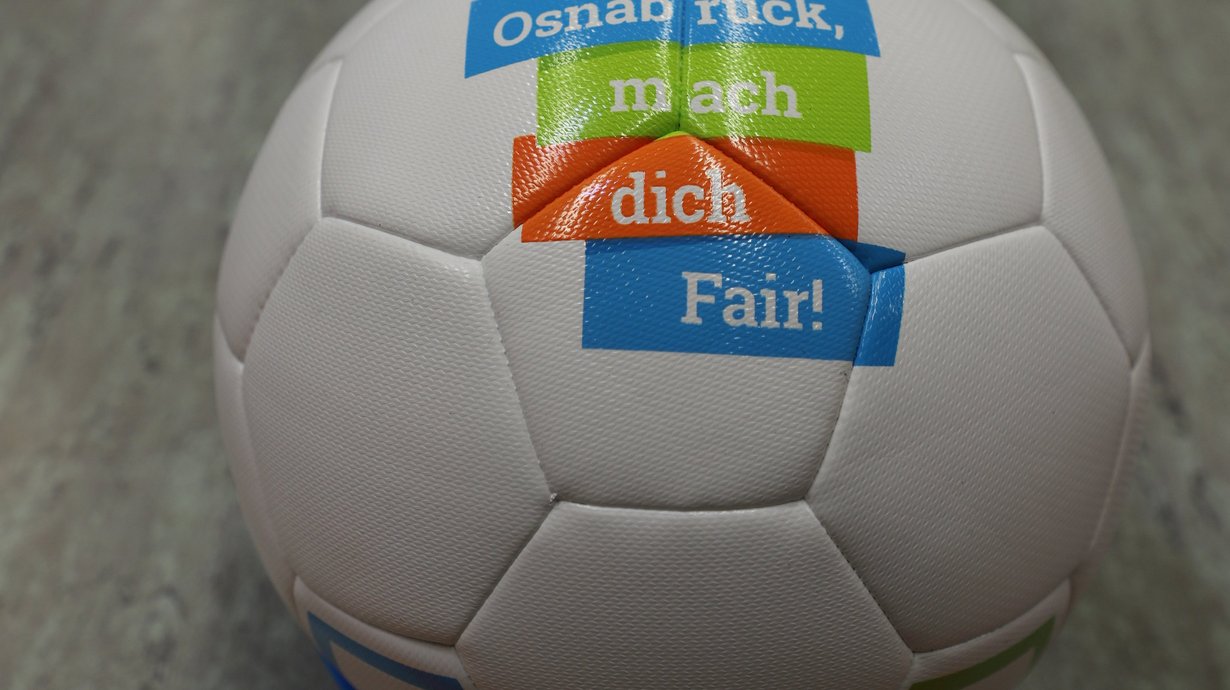 Ein Fußball liegt auf dem Boden einer Sporthalle.